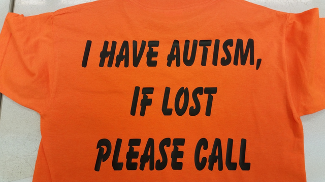 Orange safety tee reading I Have Autism, If Lost Please Call